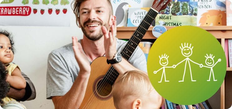 Mann mit Gitarre klatscht in die Hände, umringt von Kindern