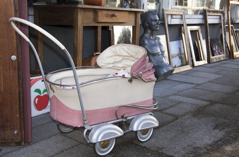 alter Kinderwagen steht vor Flohmarktware
